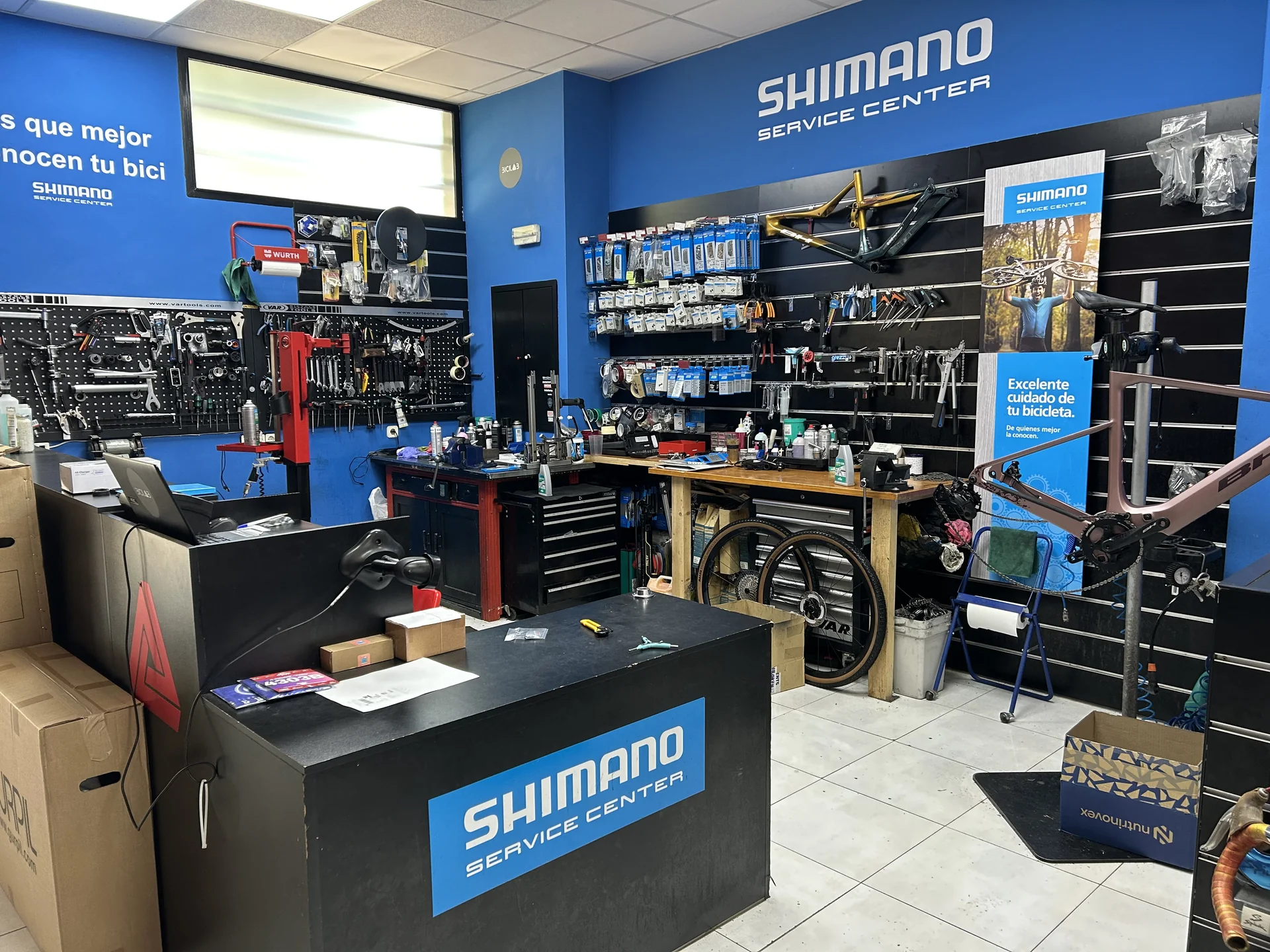 Interior del taller de BiciLAB en Pinto, Shimano Service Center, con bancos de trabajo